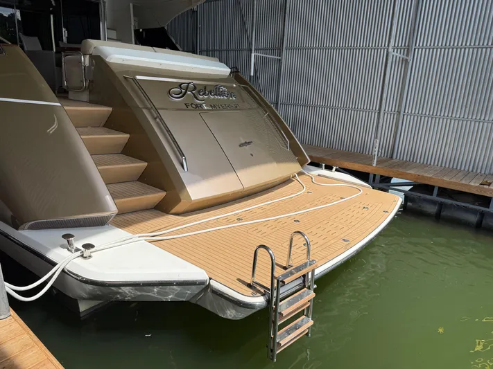 Rebellion Yacht Photos Pics Luxury Monte Carlo Yachts 76, 2012 model, docked with elegant teak deck and ladder.