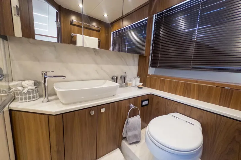  Yacht Photos Pics Luxurious bathroom in 2020 Sunseeker Predator 74 yacht with modern fixtures and wood accents.