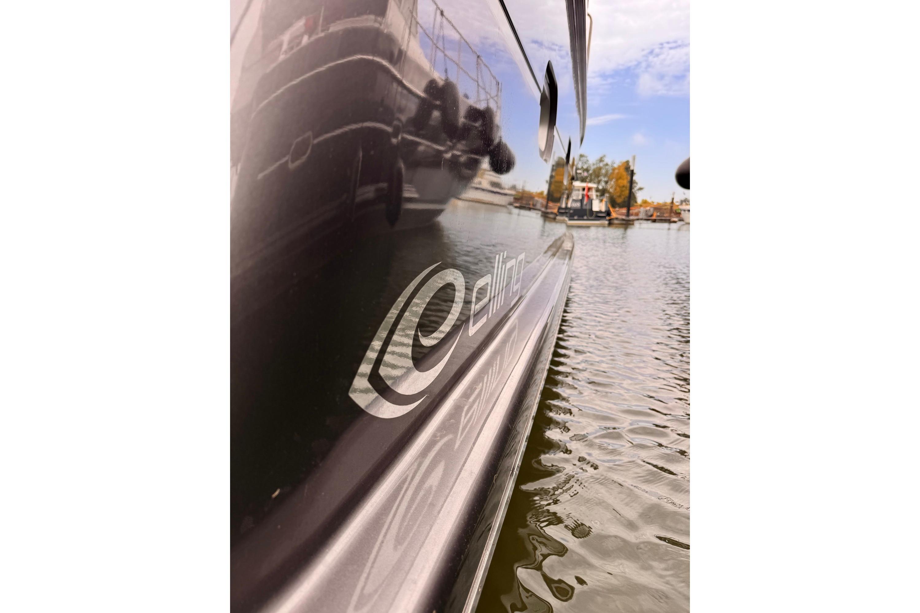 Elling E4 yacht reflecting on water, 2014 model, docked in a serene marina.