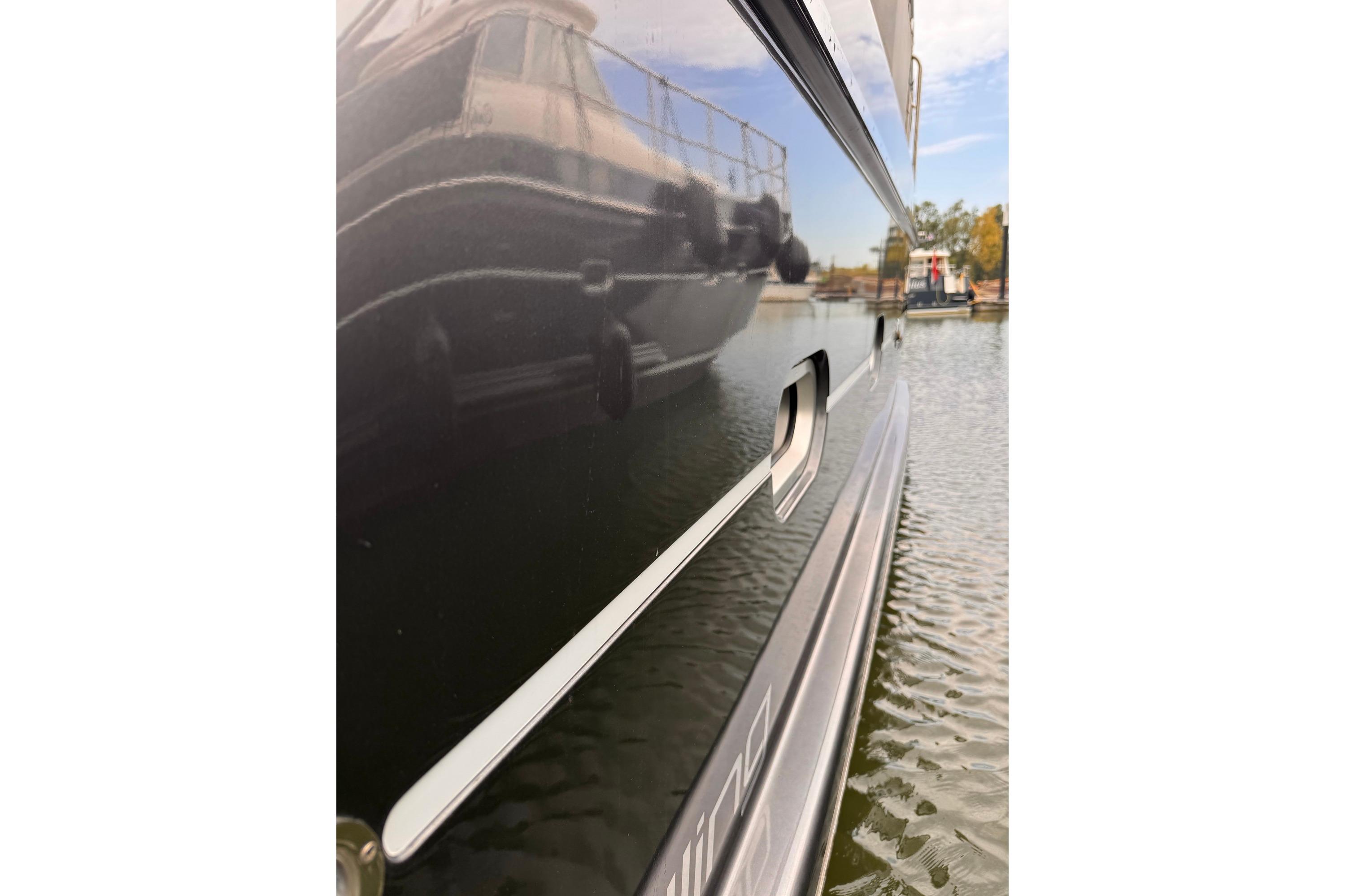 Side view of a 2014 Elling E4 yacht reflecting another boat on water.