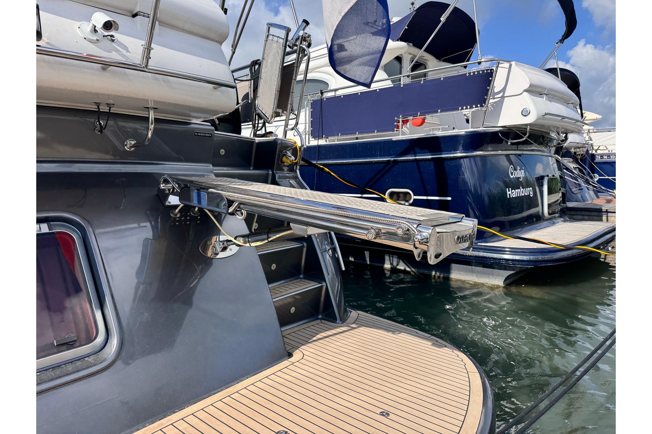 2014 Elling E4 yacht with extended gangway, docked alongside another vessel.