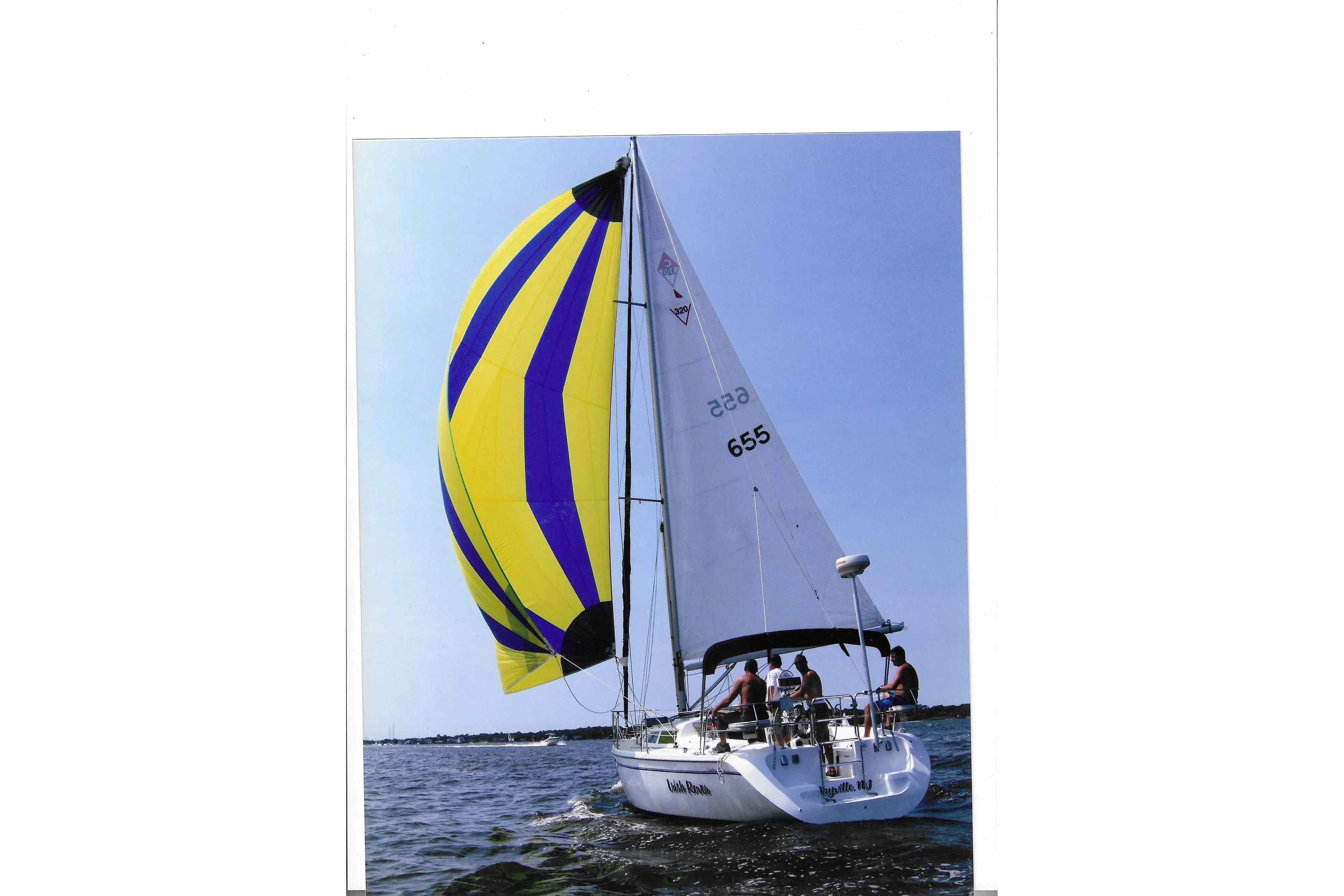 Sailing on a 1999 Catalina 320 with vibrant yellow and blue spinnaker.
