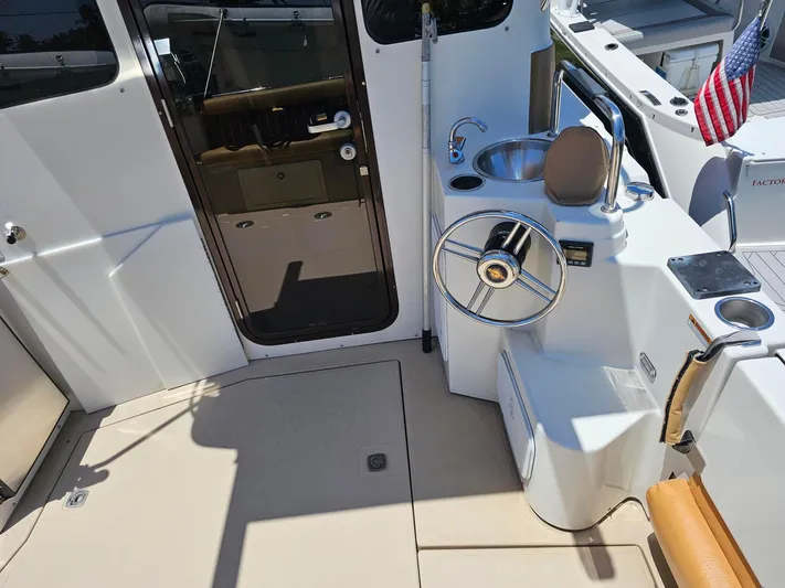  Yacht Photos Pics 2014 Ranger Tugs 31-CB cockpit with steering wheel, sink, and American flag.