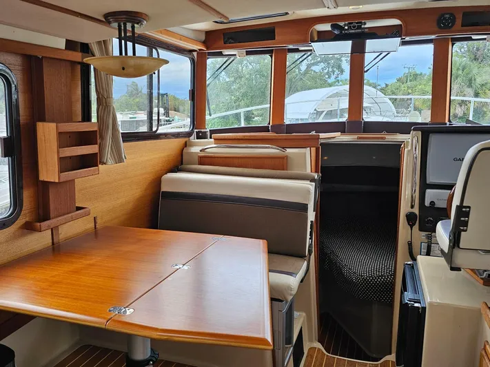  Yacht Photos Pics Interior of 2014 Ranger Tugs 31-CB boat, featuring wood finishes and seating area.