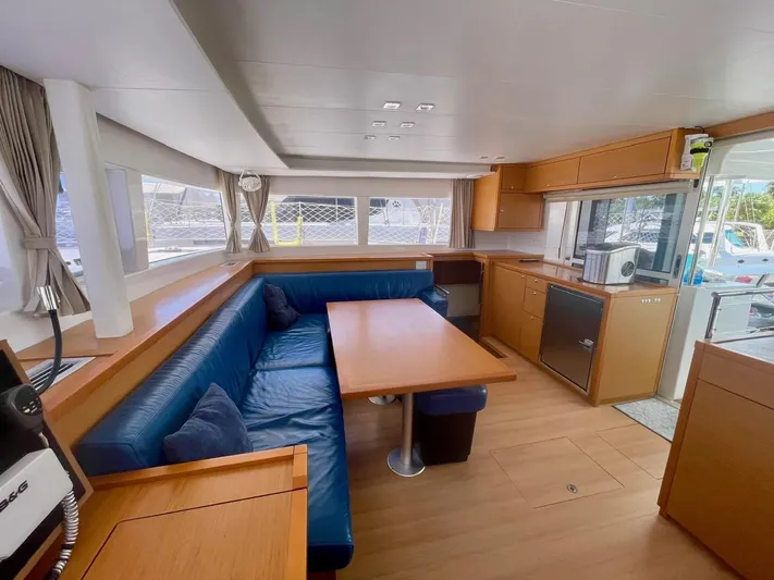 Unfettered Yacht Photos Pics Spacious interior of 2015 Lagoon 450 F catamaran with blue seating and wooden finishes.