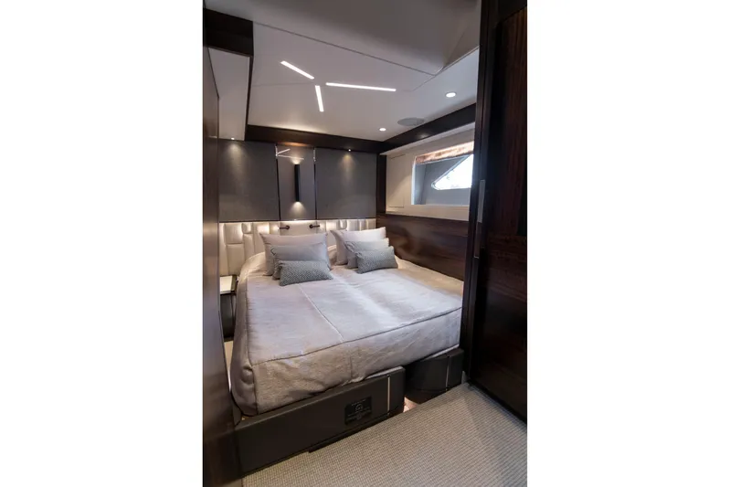 Baillies Yacht Photos Pics Luxurious bedroom interior of 2021 Sunseeker Manhattan 68 yacht, featuring modern design and cozy bedding.