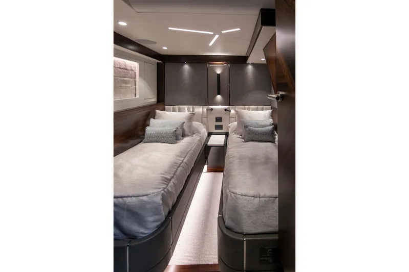 Baillies Yacht Photos Pics Luxurious twin cabin interior of 2021 Sunseeker Manhattan 68 yacht, featuring modern design and ambient lighting.