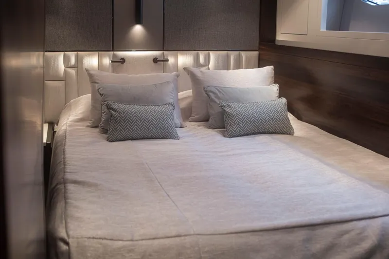 Baillies Yacht Photos Pics Luxurious bedroom interior on 2021 Sunseeker Manhattan 68 yacht, featuring elegant bedding and ambient lighting.