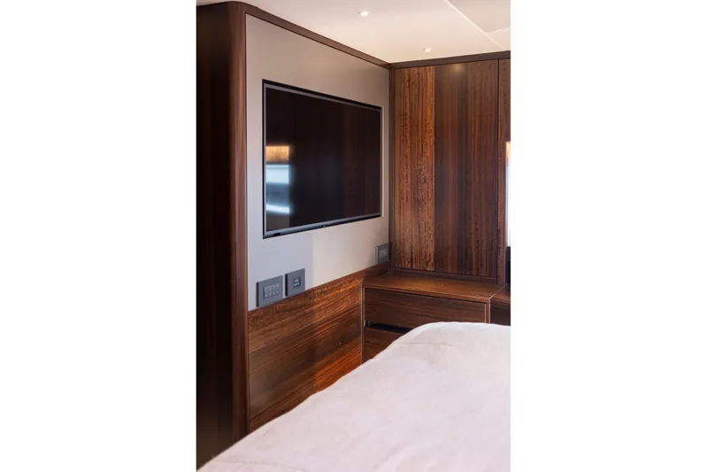 Baillies Yacht Photos Pics Luxurious interior of 2021 Sunseeker Manhattan 68 yacht with sleek wood paneling and modern TV.