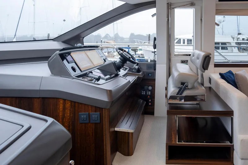 Baillies Yacht Photos Pics Interior helm of 2021 Sunseeker Manhattan 68 yacht, featuring modern controls and seating.
