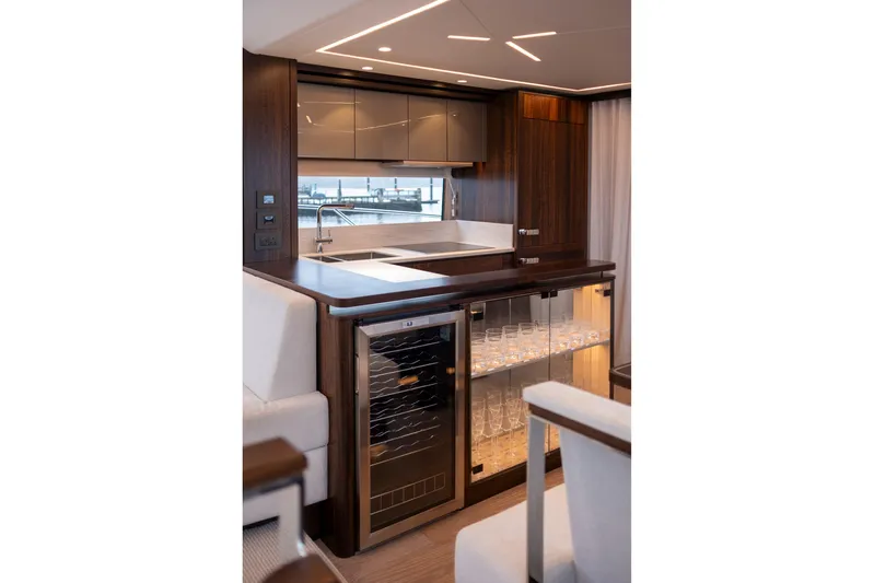 Baillies Yacht Photos Pics Luxurious kitchen area in 2021 Sunseeker Manhattan 68 yacht with modern cabinetry and glass storage.
