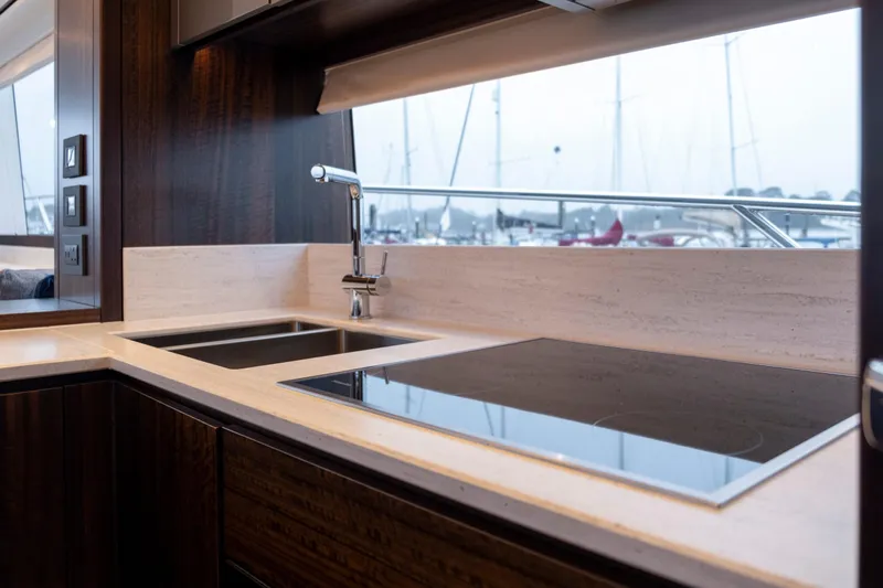 Baillies Yacht Photos Pics Luxurious kitchen interior of 2021 Sunseeker Manhattan 68 yacht with modern fixtures.