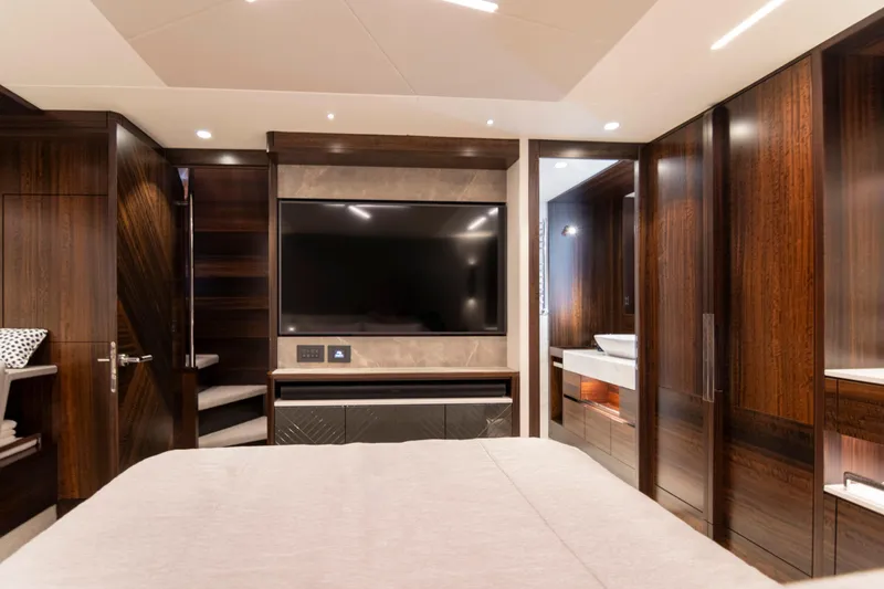 Baillies Yacht Photos Pics Luxurious interior of 2021 Sunseeker Manhattan 68 yacht with modern wood finishes and large TV.