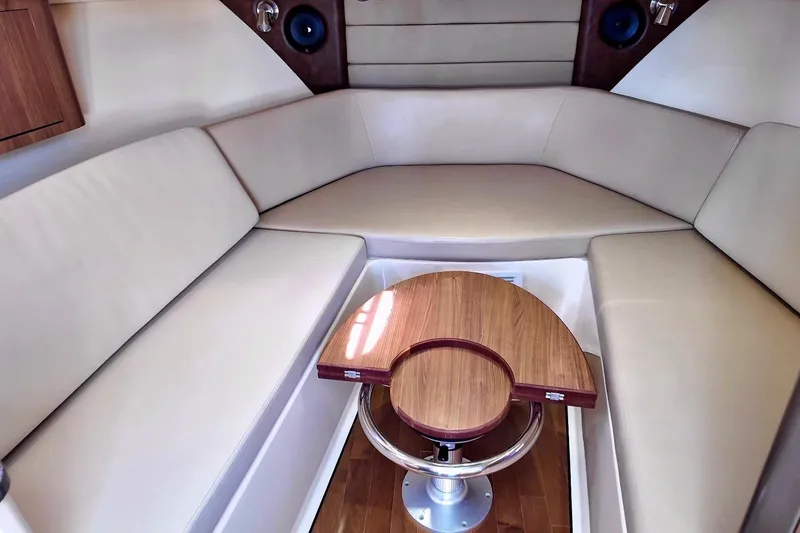Mr Ceo Yacht Photos Pics 2015 Boston Whaler 315 Conquest cabin interior with beige seating and wooden table.