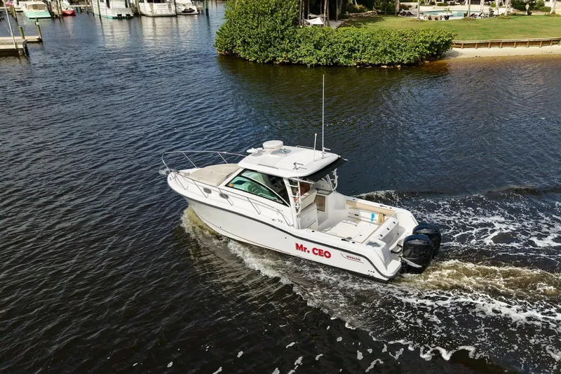 Mr Ceo Yacht Photos Pics 2015 Boston Whaler 315 Conquest boat cruising on a calm waterway.