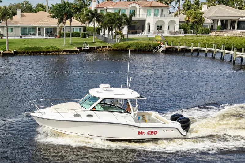 Mr Ceo Yacht Photos Pics 2015 Boston Whaler 315 Conquest boat cruising on a scenic waterway near luxury homes.