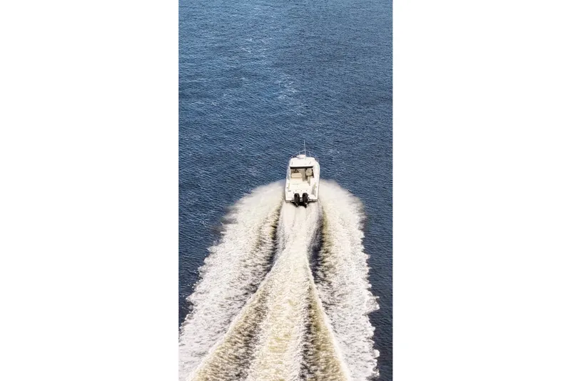 Mr Ceo Yacht Photos Pics 2015 Boston Whaler 315 Conquest cruising on open water, leaving a wake trail.