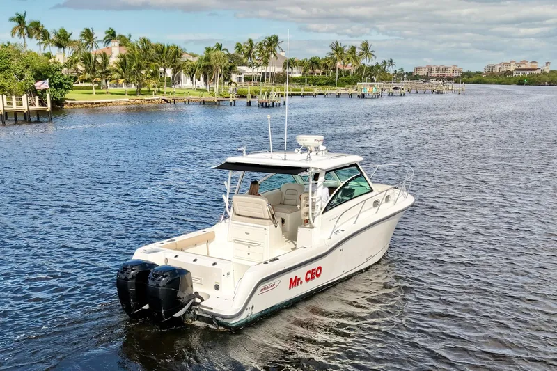 Mr Ceo Yacht Photos Pics 2015 Boston Whaler 315 Conquest boat cruising on a scenic waterway.