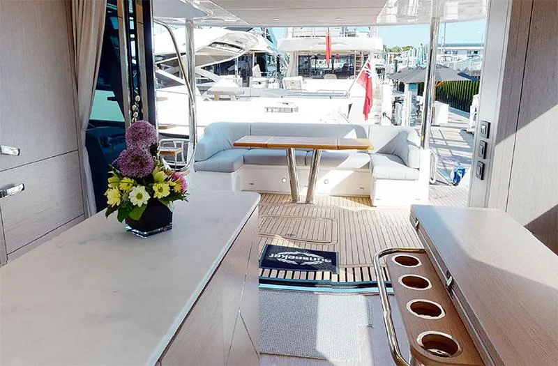  Yacht Photos Pics Luxurious interior of 2022 Sunseeker Manhattan 68 yacht with elegant seating and floral arrangement.