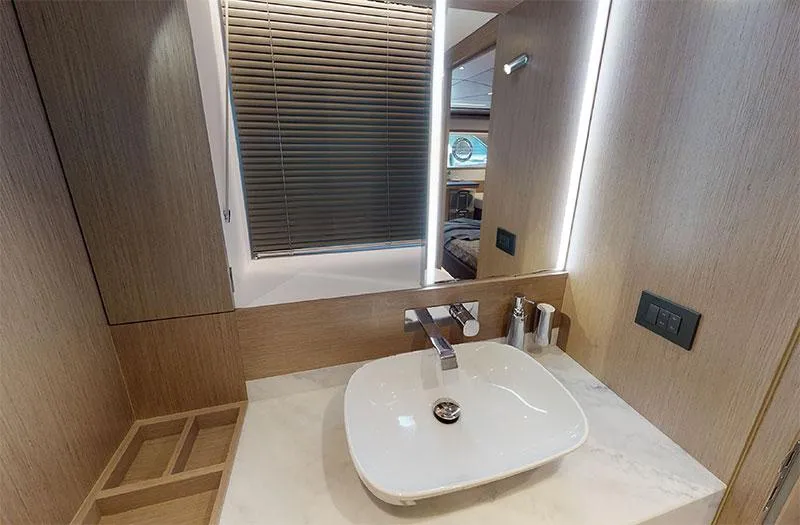  Yacht Photos Pics Luxurious bathroom in 2022 Sunseeker Manhattan 68 yacht with modern sink and wooden accents.