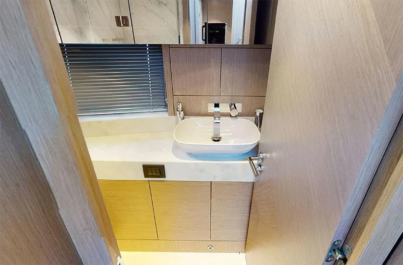  Yacht Photos Pics Modern bathroom interior on 2022 Sunseeker Manhattan 68 yacht, featuring sleek sink and wooden cabinetry.