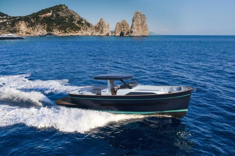  Yacht Photos Pics 2025 Apreamare Gozzo 45 cruising on blue ocean near rocky coastline.