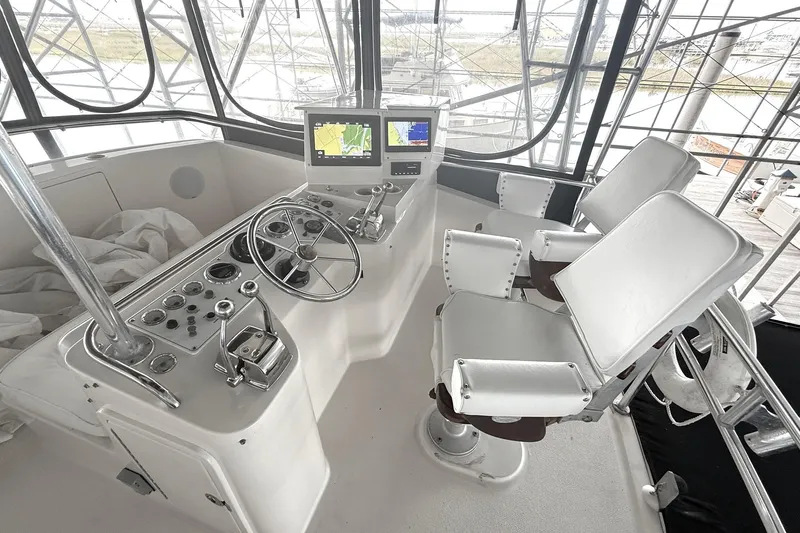  Yacht Photos Pics 1996 Riviera 39 Open Flybridge helm with dual seats, steering wheel, and navigation screens.