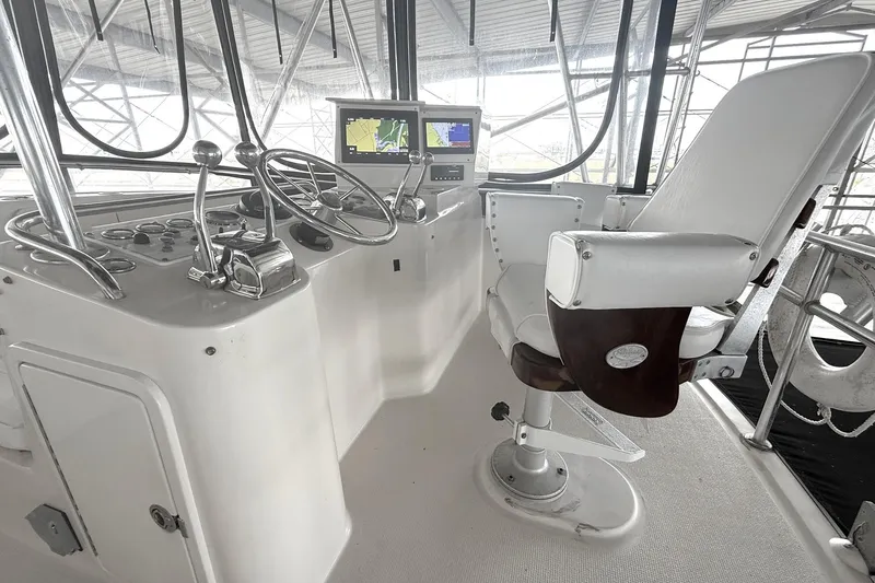  Yacht Photos Pics 1996 Riviera 39 Open Flybridge helm with steering wheel, controls, and navigation display.