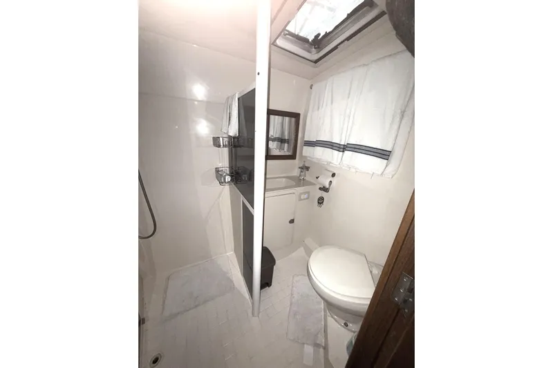  Yacht Photos Pics Bathroom interior of 1996 Riviera 39 Open Flybridge yacht, featuring shower and toilet.