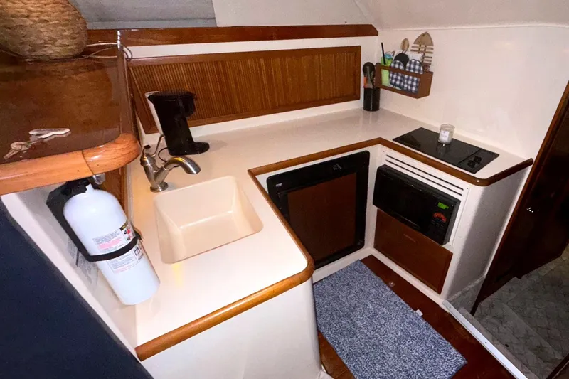  Yacht Photos Pics 1996 Riviera 39 Open Flybridge yacht kitchen with sink, stove, and microwave.
