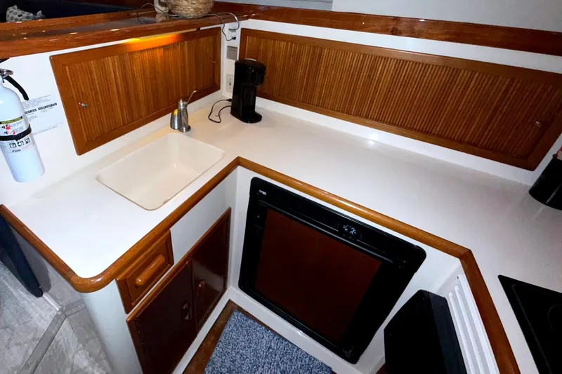  Yacht Photos Pics Compact kitchen area in a 1996 Riviera 39 Open Flybridge yacht with sink and appliances.