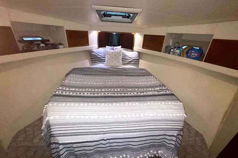  Yacht Photos Pics 1996 Riviera 39 Open Flybridge cabin with striped bedding and cozy interior.