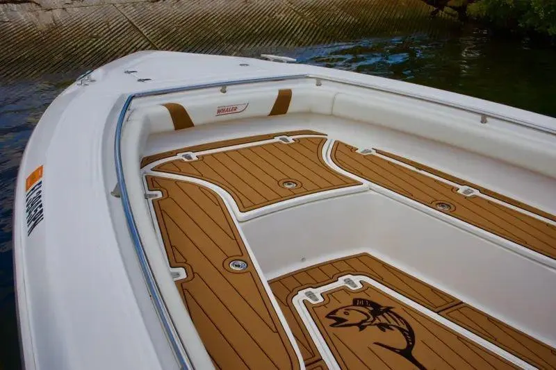  Yacht Photos Pics 2013 Boston Whaler 320 Outrage boat deck with wood accents near water.