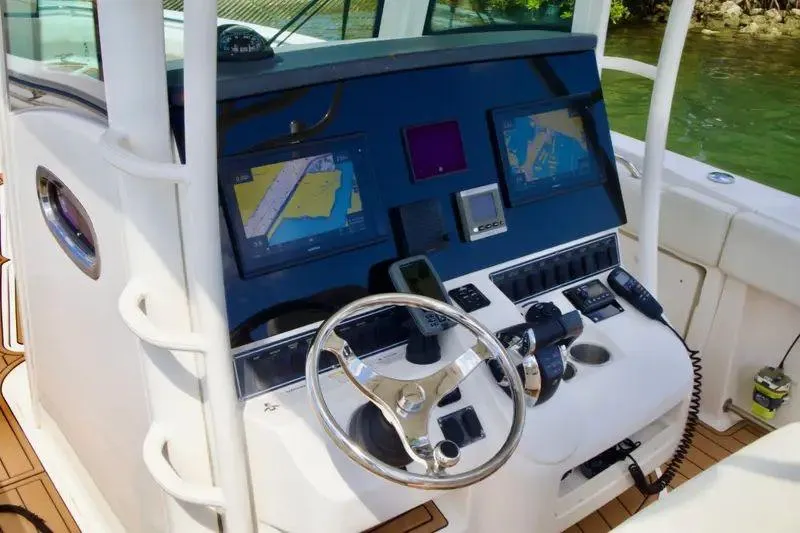  Yacht Photos Pics 2013 Boston Whaler 320 Outrage helm with navigation screens and controls.