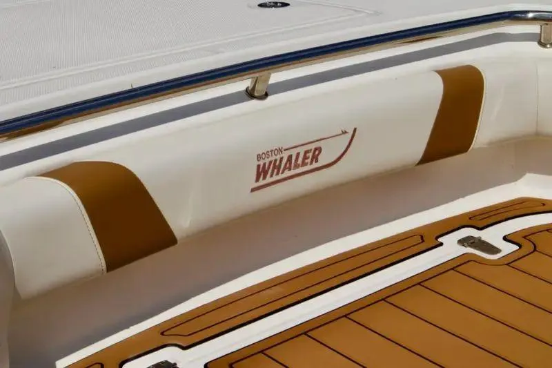  Yacht Photos Pics 2013 Boston Whaler 320 Outrage boat interior with logo and cushioned seating.