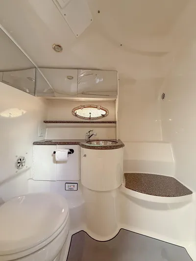Gentleman's Legacy Yacht Photos Pics 2004 Formula 400 Super Sport boat bathroom with sink, toilet, and storage cabinets.
