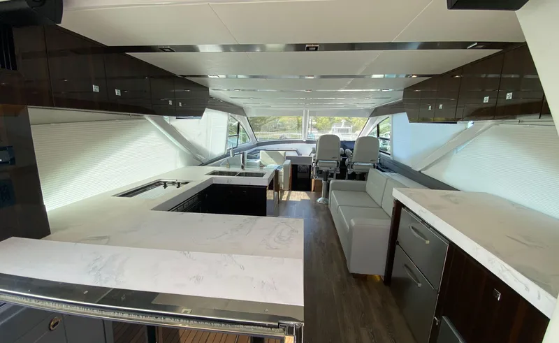 Radiant Yacht Photos Pics Luxurious interior of 2022 Cruisers Yachts 60 Fly with modern kitchen and seating area.