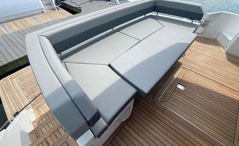 Radiant Yacht Photos Pics Luxurious seating area on 2022 Cruisers Yachts 60 Fly, featuring sleek design and wooden deck.