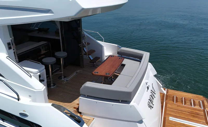 Radiant Yacht Photos Pics 2022 Cruisers Yachts 60 Fly, luxurious deck with seating and table, overlooking serene water.