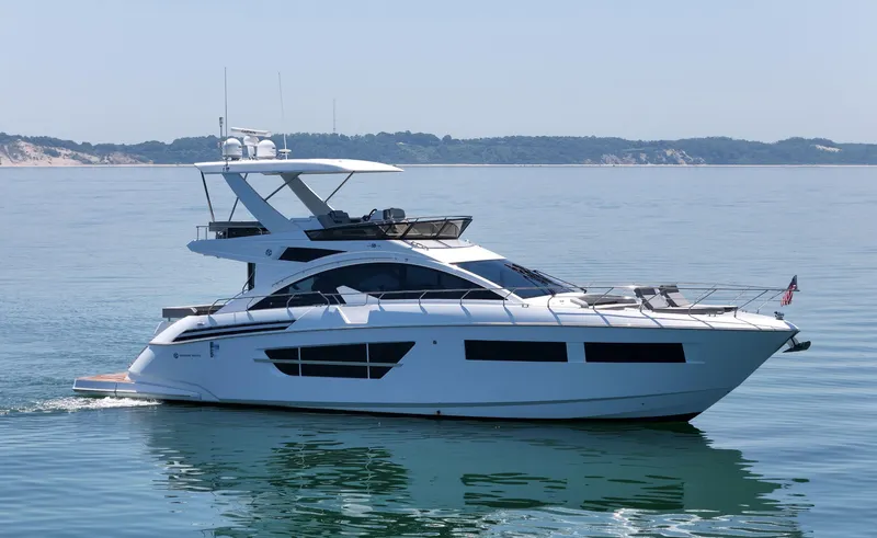 Radiant Yacht Photos Pics Luxury 2022 Cruisers Yachts 60 Fly on calm water, showcasing sleek design and elegance.