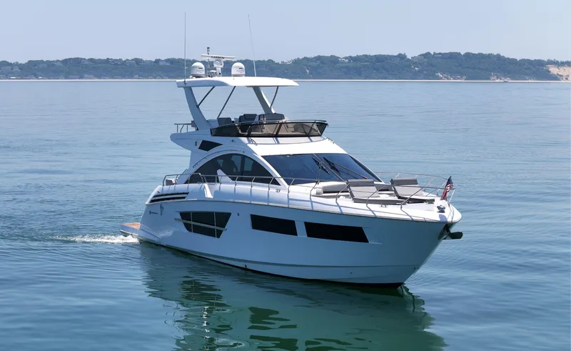 Radiant Yacht Photos Pics 2022 Cruisers Yachts 60 Fly on calm water, showcasing sleek design and luxury features.