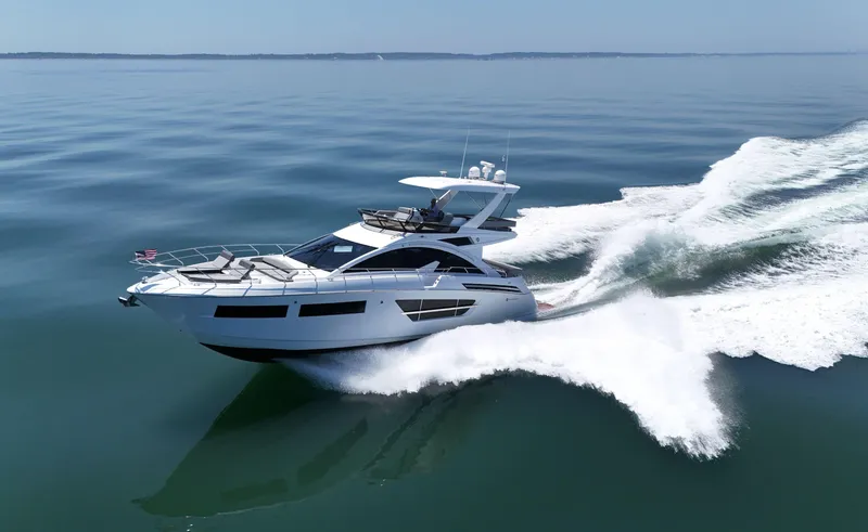 Radiant Yacht Photos Pics 2022 Cruisers Yachts 60 Fly cruising on calm waters, creating a dynamic wake.