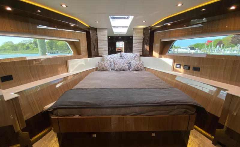 Radiant Yacht Photos Pics Luxurious bedroom interior of 2022 Cruisers Yachts 60 Fly with elegant wood finish and scenic windows.