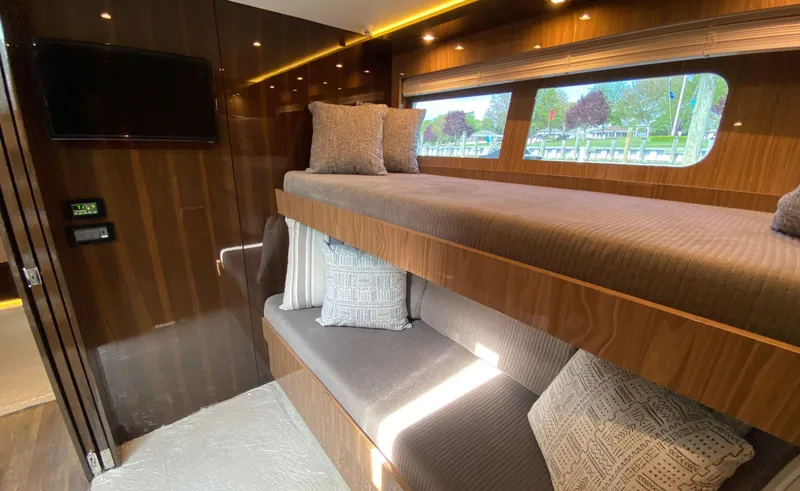 Radiant Yacht Photos Pics Luxurious 2022 Cruisers Yachts 60 Fly cabin with bunk beds and elegant wood finish.
