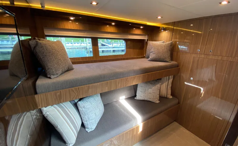 Radiant Yacht Photos Pics Luxurious 2022 Cruisers Yachts 60 Fly cabin with wooden interior and cozy bunk beds.