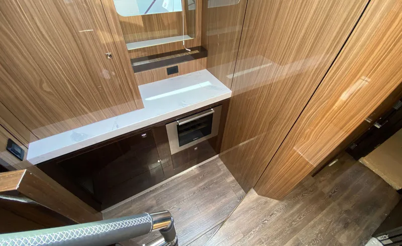 Radiant Yacht Photos Pics Modern kitchen area in 2022 Cruisers Yachts 60 Fly with wood paneling and built-in oven.