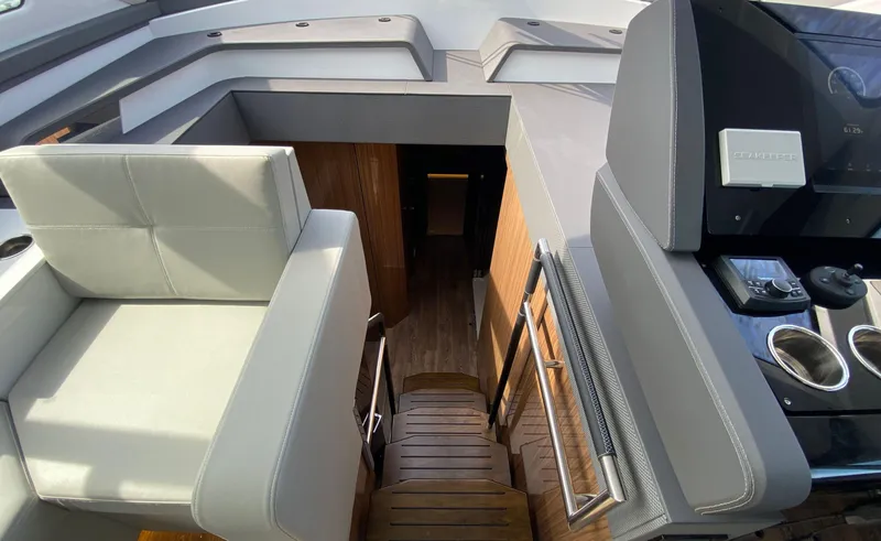 Radiant Yacht Photos Pics Interior view of 2022 Cruisers Yachts 60 Fly, featuring modern seating and control panel.