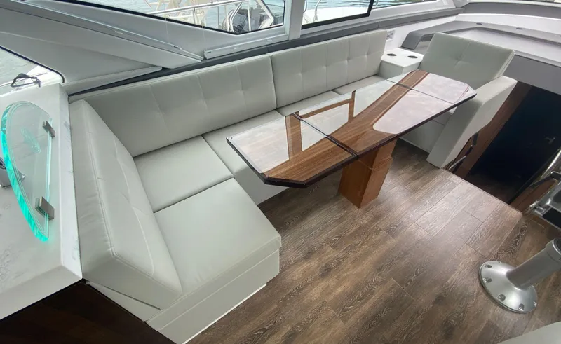 Radiant Yacht Photos Pics Luxurious interior of 2022 Cruisers Yachts 60 Fly with elegant seating and wooden table.