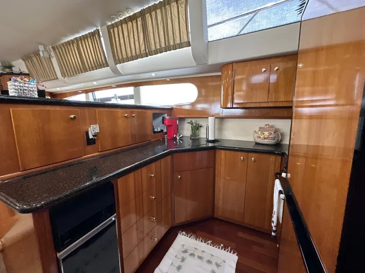  Yacht Photos Pics Luxurious kitchen interior of 2002 Carver 466 Motor Yacht with wood cabinetry and modern appliances.