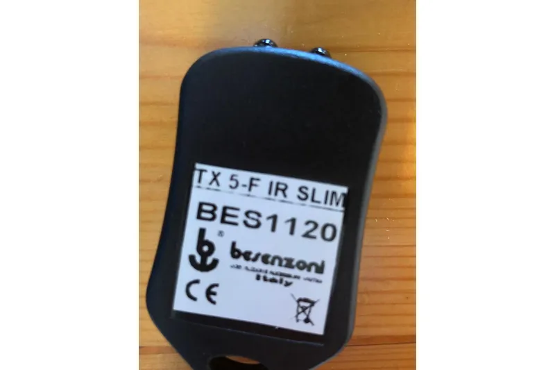  Yacht Photos Pics Remote control labeled "TX 5-F IR SLIM BES1120" by Besenzoni, Italy, on wooden surface.
